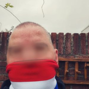 Hollandse nekwarmer in rood, wit en blauw met fleece binnenkant en katoenen buitenkant, gedragen door een supporter.