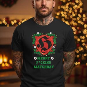 Zwart T-shirt met een rode en groene kerst-voetbal opdruk, inclusief de tekst 'MERRY F*CKING MATCHDAY' en een rood hart/schild embleem.